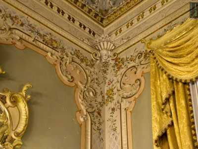 ...posizionate in elaborate composizioni murali con fregi a rialzo, festoni colorati e volti di putti situate negli angoli
